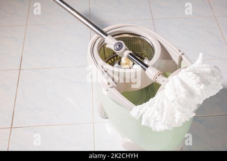 Mop with microfiber head spinning on the bucket Stock Photo