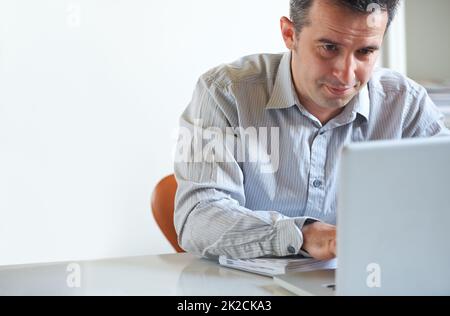 Trying to meet his deadline. Cropped shot of a stressed out businessman using a laptop. Stock Photo