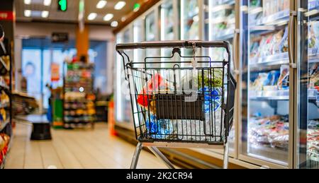 A shopping cart with grocery products in a supermarket Stock Photo