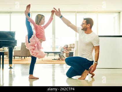 Youve got this. Full length shot of a mature man helping his daughter practice for her ballet recital. Stock Photo