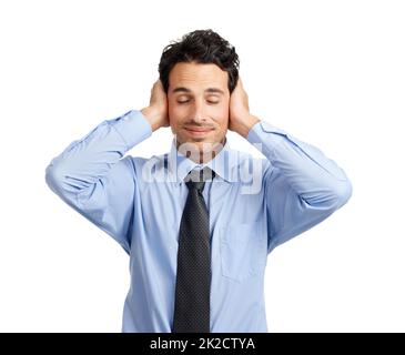 Blissfully ignorant. Studio shot of a handsome businessman covering his ears. Stock Photo