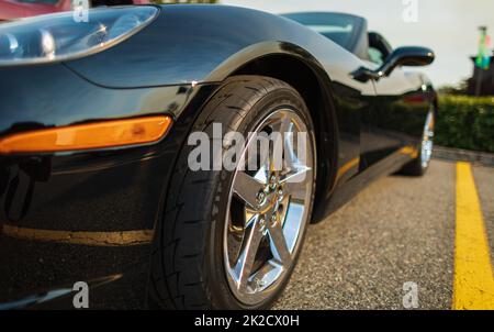 Wing, wheel and car headlight black, close-up. Detail on one of the LED headlights modern car. Stock Photo