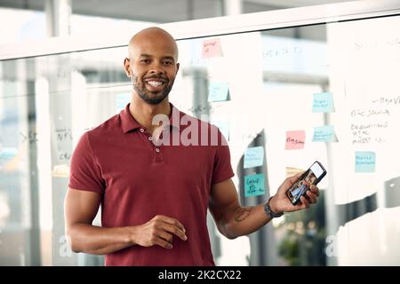 I just forwarded my proposal to my client. Cropped shot of a young businessman holding his cellphone. Stock Photo