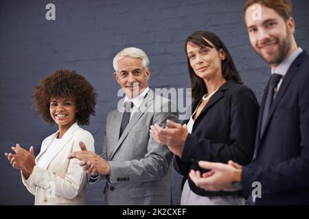 Applauding your accomplishments. Portrait of a group of professional coworkers giving a round of applause. Stock Photo