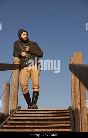 Smoking a pipe. Cropped shot of a bearded man smoking a pipe outside. Stock Photo