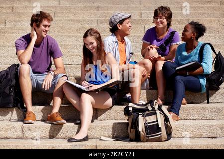 Loving the university vibes. Shot of a college students hanging out on campus. Stock Photo