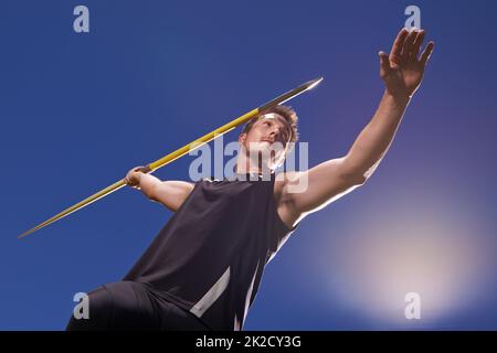 this is going the distance. Shot of a lone man throwing a javelin outside. Stock Photo