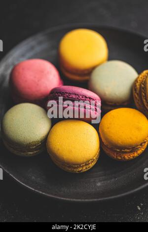 Sweet colorful macarons. Traditional french macaroons. Tasty dessert on plate. Stock Photo