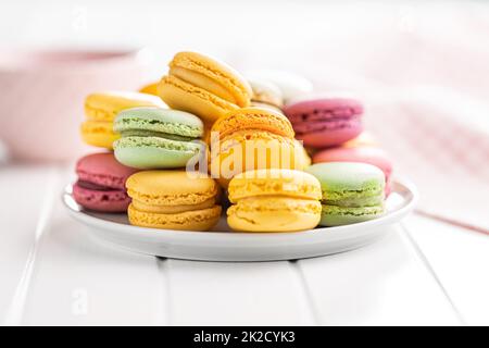 Sweet colorful macarons. Traditional french macaroons. Tasty dessert on plate. Stock Photo