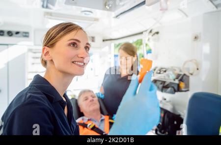Paramedic looking after the drop injection in an ambulance Stock Photo