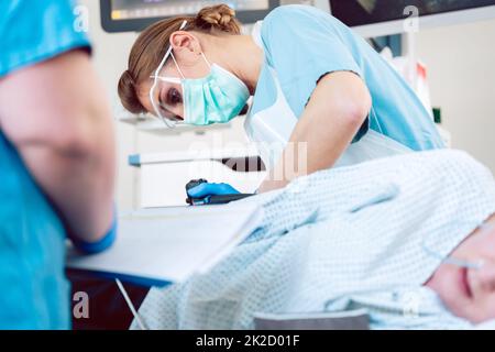 Proctologist during colonoscopy inserting endoscope Stock Photo