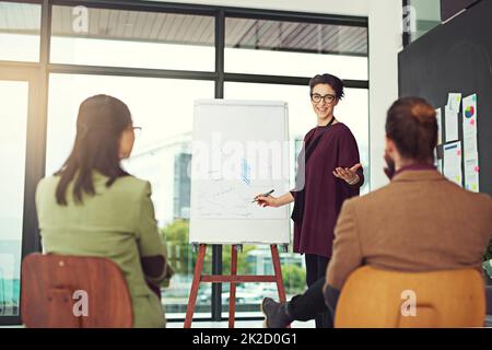 Moving the company forward head-on towards success. Cropped shot of a young creative giving a presentation to her colleagues in an office. Stock Photo