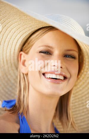 Poolside style. A young blonde woman wearing a hat and looking at the camera. Stock Photo