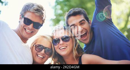 Enjoying the vibe. Four young friends cheering and enjoying each others company at a music festival. Stock Photo
