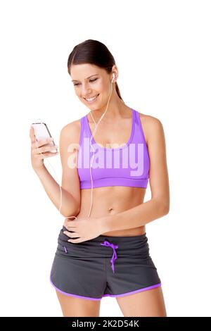 Tunes to workout with.... Shot of a sporty young women listing to music on an mp3 player isolated on white. Stock Photo