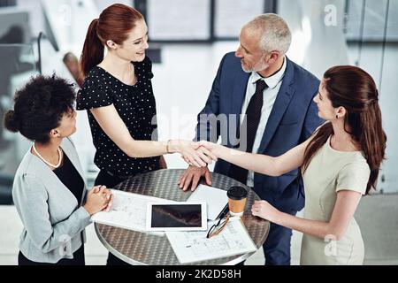 An alliance built on trust. Shot of two businesswomen shaking hands during a team meeting at work. Stock Photo