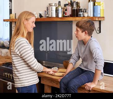 Conversation and sandwiches with mom. A cropped shot of a mother making her young son a sandwich in the kitchen. Stock Photo