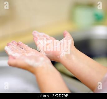 Doing it the way that mommy taught me. Shot of an unidentifiable little girl washing her hands at home. Stock Photo