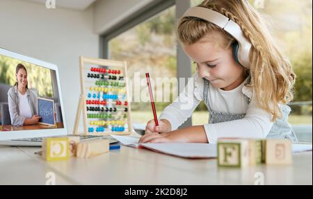 Virtual class, learning math and student studying on education webinar, learning on video call and writing notes in notebook in house. Girl on laptop Stock Photo