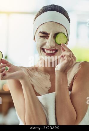 Its both cooling and purifying for my skin. Shot of an attractive young woman holding cucumber slices in front of her eyes. Stock Photo