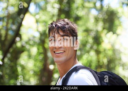 Surrounded by natures beauty. Shot of a handsome young man hiking in the forest. Stock Photo