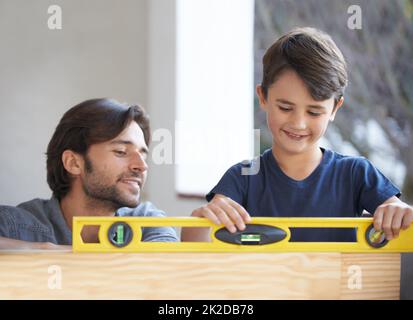 Teaching his son all about carpentry. A father and son doing woodwork together. Stock Photo