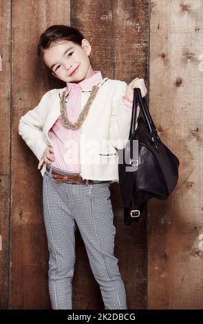 Ive got it all ... in my bag. Portrait of an adorable little girl dressed fashionably with a handbag. Stock Photo