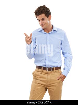 I have the perfect space for you. Portrait of a handsome young man in a studio pointing off camera. Stock Photo