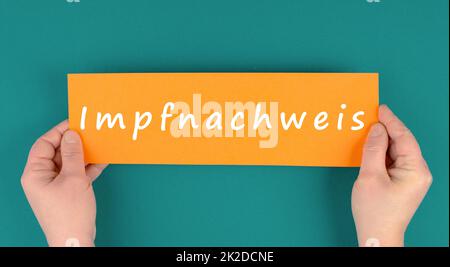 The word proof of vaccination is standing in german language on a paper, covid-19 regulation Stock Photo