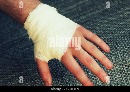 Injured painful hand with white gauze bandage Stock Photo