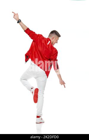 young man standing dancing rising leg spreading hands Stock Photo