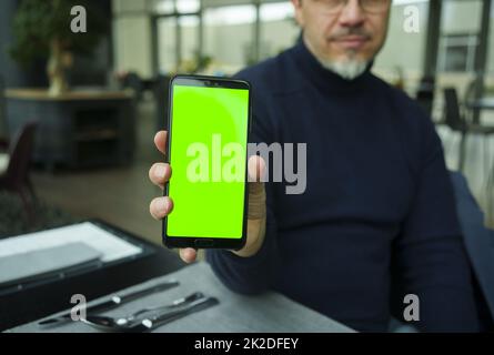 Man using showing phone in restaurant or cafe Stock Photo