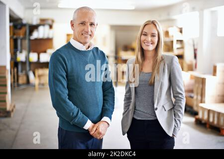 Its a big warehouse and a big job. Portrait of a two managers standing in a warehouse. Stock Photo