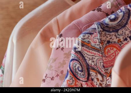 collection of women's clothes hanging on rack for sale Stock Photo
