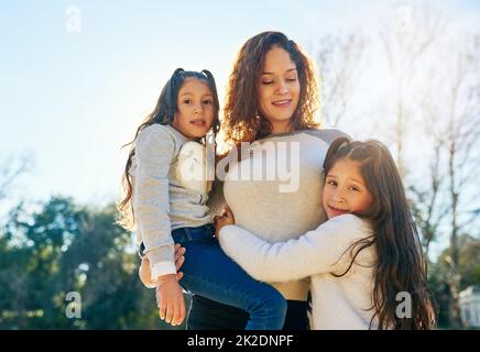 Mothers and daughters always have a special bond. Cropped shot of a beautiful young mother and her adorable daughters outdoors. Stock Photo