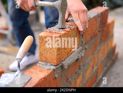 Laying the foundation one brick at a time. Shot of a master bricklayer at work. Stock Photo