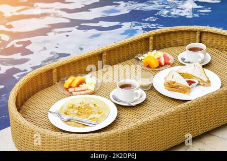 Delicious floating breakfast in the swimming pool Stock Photo