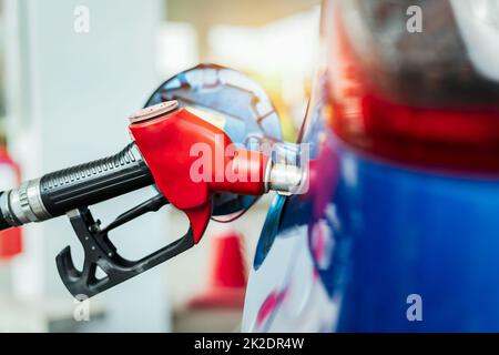 Car fueling at gas station. Refuel fill up with petrol gasoline. Petrol pump filling fuel nozzle in fuel tank of car at gas station. Petrol industry and service. Petrol price and oil crisis concept. Stock Photo