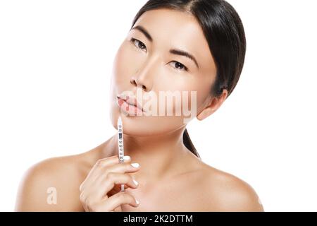 Asian young woman during lips augmentation procedure. Stock Photo