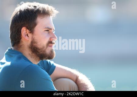 Pensive relaxed man contemplating views sitting in a lake Stock Photo