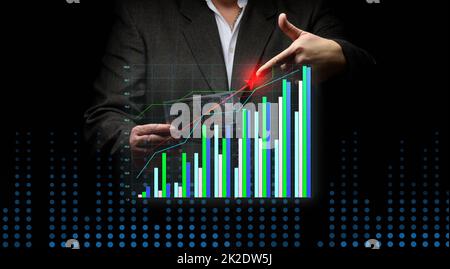 businessman in a suit holds a pack of paper american dollars against the background of a holographic chart with growing indicators. The concept of high business profitability, income growth Stock Photo