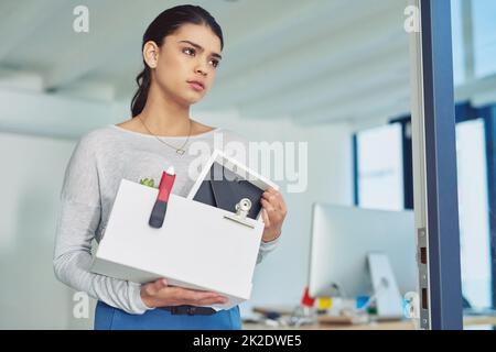 Theres always a new opportunity to move on to. Shot of an unhappy businesswoman holding her box of belongings after getting fired from her job. Stock Photo