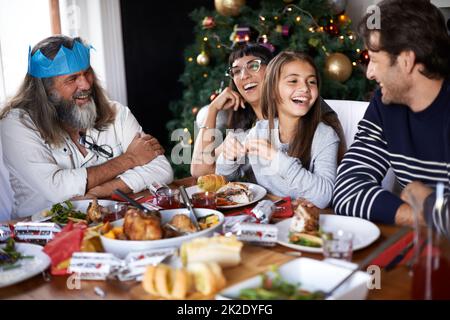 Mom thinks its funny she cant cook. Shot of a family celebrating christmas around a feast. Stock Photo