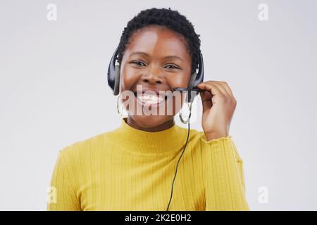 Confident call centre agents create confident customers. Studio portrait of an attractive young female customer service representative wearing a headset against a grey background. Stock Photo