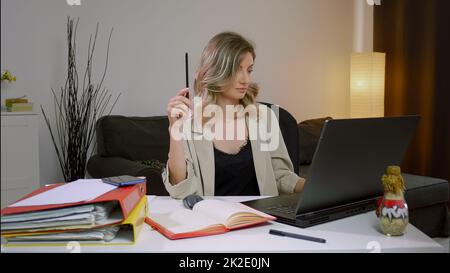 Female manager making business notes on notebook, working alone in office. Stock Photo