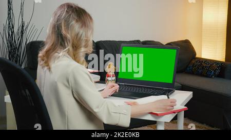 Back View of business Woman at Laptop with Green Screen for Copy Space. Chromakey Mockup. Stock Photo