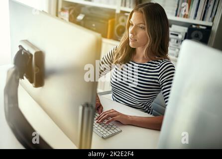Dedicated to her business. High angle shot of a young woman working on a computer in her home office. Stock Photo