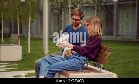 Young happy student colleagues during coffee break patio in the park. Friendly atmosphere outdoor. Stock Photo