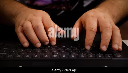 Man hands typing on laptop keyboard. Close up human hands on keyboard Front view. Stock Photo