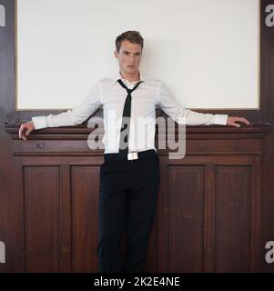 He has a relaxed attitude. Portrait of a handsome young man in a suit with copyspace behind him. Stock Photo